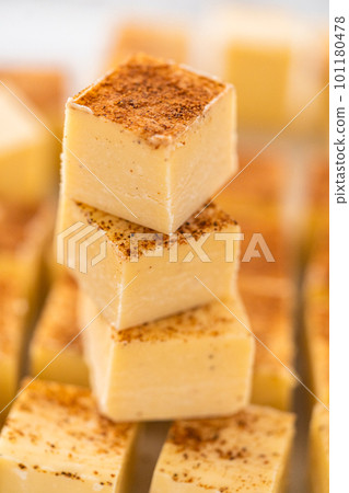 Homemade eggnog fudge pieces on a white cutting board. Homemade eggnog fudge pieces on a white cutting board. 101180478