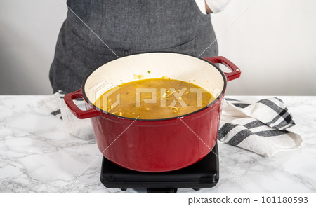 Cooking chicken noodle soup with kluski noodles in an enameled dutch oven. Cooking chicken noodle soup with kluski noodles in an enameled dutch oven. 101180593