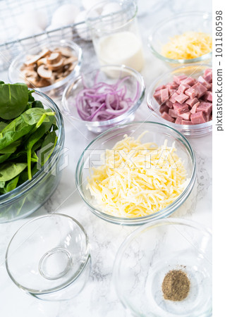 Ingredients in glass mixing bowls to prepare spinach and ham frittata. Ingredients in glass mixing bowls to prepare spinach and ham frittata. 101180598