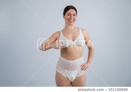 Woman in adult diapers smiling and showing thumbs up. Urinary incontinence problem. Woman in adult diapers smiling and showing thumbs up. Urinary incontinence problem. 101180606