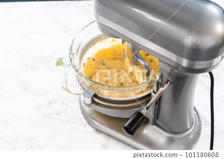 Mixing ingredients in kitchen mixer to bake mini Easter bread kulich. 101180608