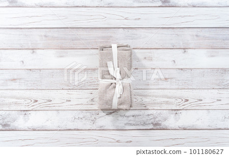 Flat lay. Stack of a new linen dinner napkin on a white wooden table. Flat lay. Stack of a new linen dinner napkin on a white wooden table. 101180627