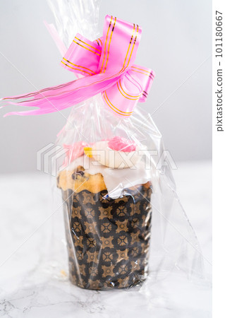 Wrapped mini Easter bread kulich with lemon glaze, decorated with sprinkles and meringue bird-shaped cookies as a good gift. Wrapped mini Easter bread kulich with lemon glaze, decorated with sprinkles and meringue bird-shaped cookies as a good gift. 101180667