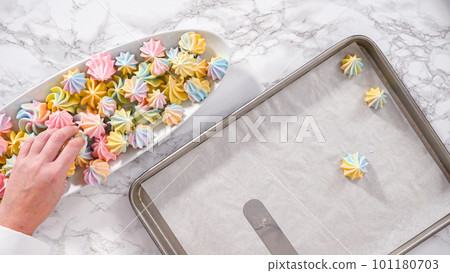 Step by step. Flat lay. Freshly baked unicorn meringue cookies on a baking sheet with a parchment paper. Step by step. Flat lay. Freshly baked unicorn meringue cookies on a baking sheet with a parchment paper. 101180703