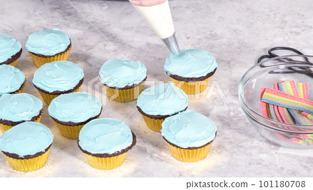 Step by step. Decorating chocolate cupcakes with buttercream frosting and rainbow candy. 101180708