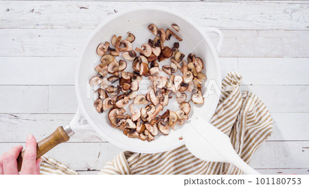 Flat lay. Sauteed organic baby bella mushrooms in a white frying pan. Flat lay. Sauteed organic baby bella mushrooms in a white frying pan. 101180753