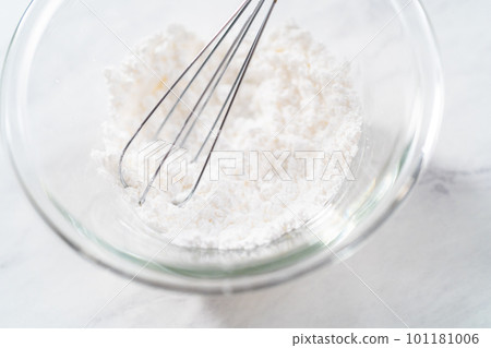 Mixing ingredients with a hand whisk to prepare powdered sugar dusting. Mixing ingredients with a hand whisk to prepare powdered sugar dusting. 101181006