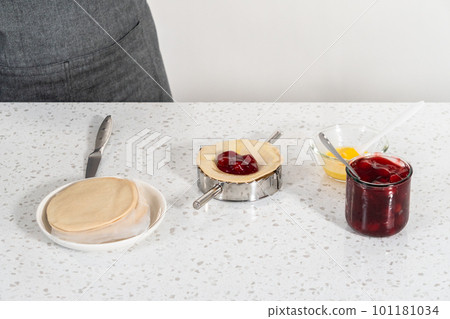 Filling empanada dough with cherry pie filling to make sweet cherry empanadas in the air fryer. 101181034