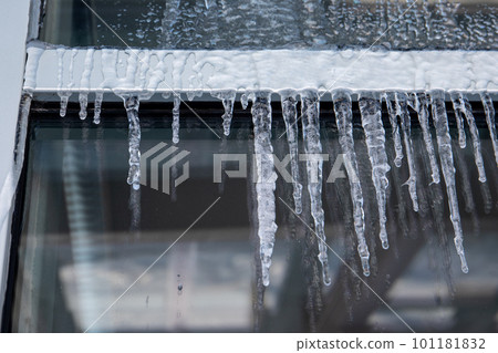 Modern glazed office building. Icicles and ice, thaw Modern glazed office building. Icicles and ice, thaw 101181832
