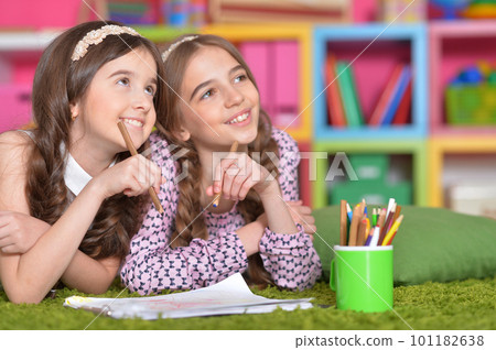 Two cute little girls drawing with pencils 101182638
