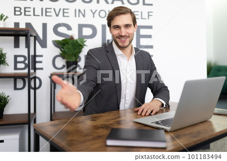 office worker stretches out his hand while sitting in the office at the workplace 101183494