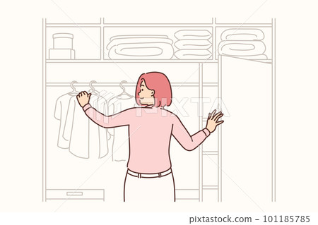 Woman stands with back to screen near large wardrobe closet choosing outfit for going to work Woman stands with back to screen near large wardrobe closet choosing outfit for going to work 101185785