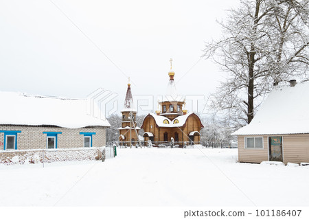 winter, wooden church in the village covered with snow 101186407
