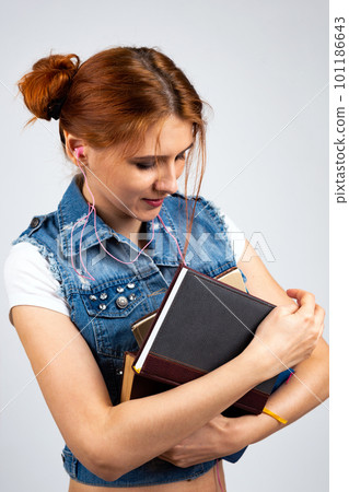 preparation for the session, study, a girl with red hair in jeans sits on the floor with books in her hands 101186643