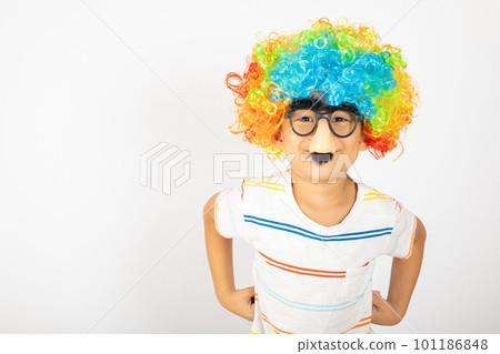April Fool's Day. Portrait of Funny kid boy clown wears a curly wig colorful a big nos and glasses and has a mustache isolated on white background with copy space, Happy child festive decor 101186848
