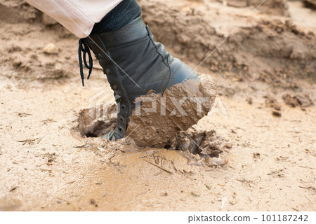 the worker's black boot was stuck in the mud the worker's black boot was stuck in the mud 101187242