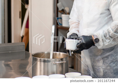 Catering, a cook in the kitchen in a white robe and gloves prepares food in disposable containers Catering, a cook in the kitchen in a white robe and gloves prepares food in disposable containers 101187244