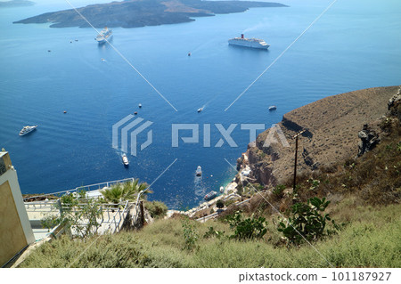 Boats floating in the Aegean Sea overlooking the town of Fira 101187927