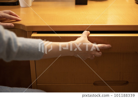 Woman's hand opening the desk drawer [Night] 101188339