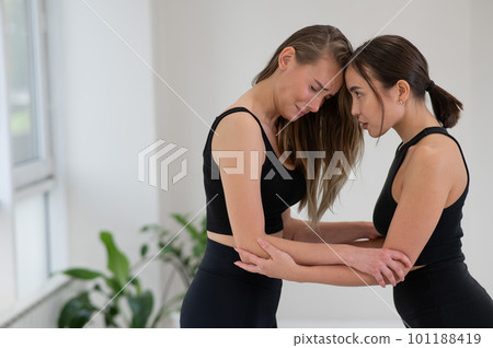 Caucasian woman stands on sadhu boards with therapist support. 101188419