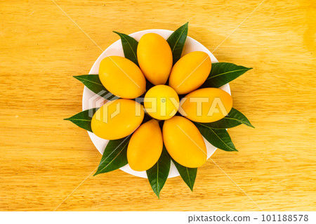 Top view of ripe sweet yellow marian plum with leaves. Top view of ripe sweet yellow marian plum with leaves. 101188578