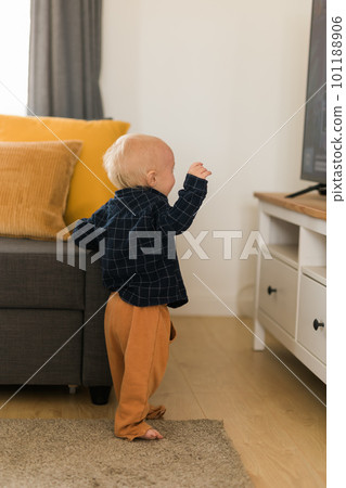 Caucasian baby newborn infant making first steps. Cute toddler kid child son boy learning walking creeping on living room. Childcare and childhood concept Caucasian baby newborn infant making first steps. Cute toddler kid child son boy learning walking creeping on living room. Childcare and childhood concept 101188906