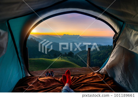 Woman cross leg on blanket in camping tent with sleeping bags on mountain hill. view from inside with Doi luang chiang dao mountains. 101189661