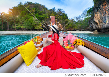 Beautiful girl in red dress on longtail boat at Koh Lao Lading island, Thailand. 101189692