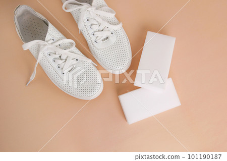 White sneakers with a melamine sponge on a beige background. 101190187