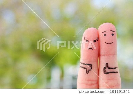 Fingers art of couple. Woman showing thumb down and man showing thumb up. Concept of disagreement in family. 101191241