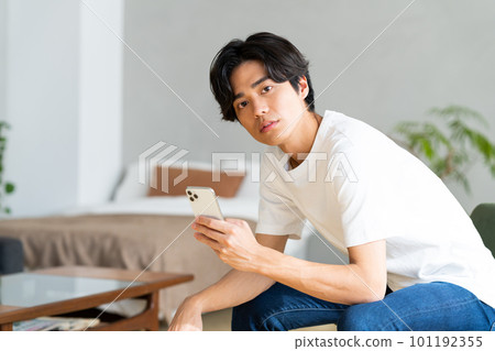 A young woman looking at a smartphone at home A young woman looking at a smartphone at home 101192355