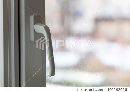 Closed white plastic pvc window in winter on a cloudy day. 101192616