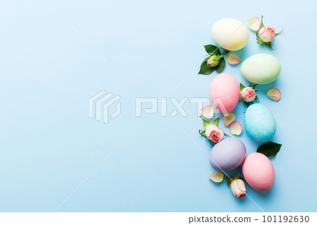 Happy Easter. Easter eggs on colored table with yellow roses. Natural dyed colorful eggs background top view with copy space 101192630