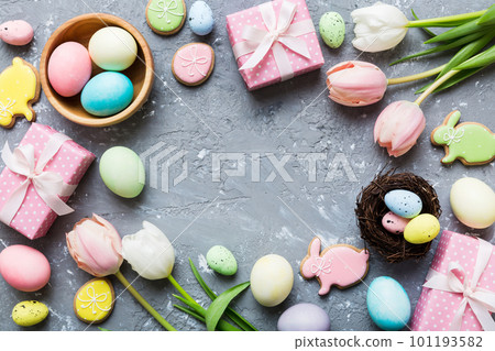 Easter frame with eggs, gift box and tulip on a colored background. The minimal concept. Top view Happy Easter composition. Card with a copy space of the place for the text Easter frame with eggs, gift box and tulip on a colored background. The minimal concept. Top view Happy Easter composition. Card with a copy space of the place for the text 101193582
