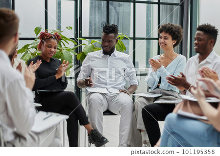 Male mentor executive leader talking during briefing, multi-ethnic workers engaged in corporate training sitting attentively listen 101195358