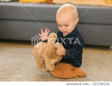 Child playing with teddy bear. Little boy hugging his favorite toy at home 101196139