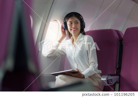 Beautiful Asian businesswoman working with digital tablet in aeroplane. working, travel, business concept Beautiful Asian businesswoman working with digital tablet in aeroplane. working, travel, business concept 101196205