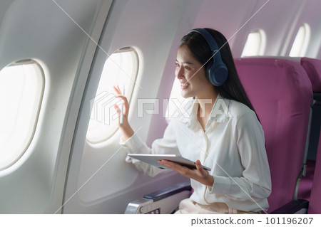 Beautiful Asian businesswoman working with digital tablet in aeroplane. working, travel, business concept 101196207