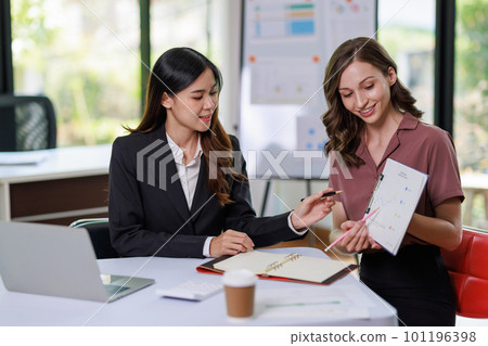 Concept of business office woman working,Businesswoman smile while working about her invesment plan with analyzing document and business investment graph data by using laptop on desk in workstation. 101196398