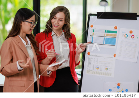 Concept of business office woman working,Businesswoman smile while working about her invesment plan with analyzing document and business investment graph data by using laptop on desk in workstation. Concept of business office woman working,Businesswoman smile while working about her invesment plan with analyzing document and business investment graph data by using laptop on desk in workstation. 101196417