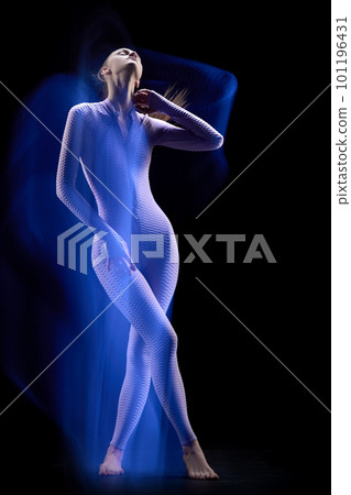 Cyberpunk girl wearing cyber suit walking in motion over dark background. Futuristic woman from future. Mixed neon light 101196431