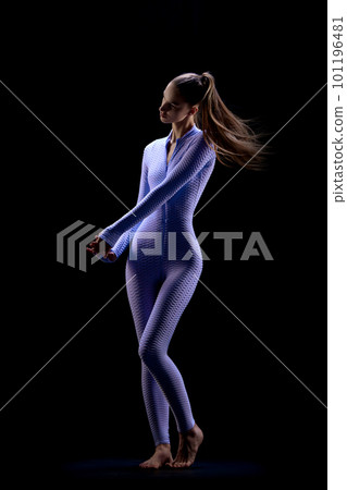 Shot of adorable young woman with long hair wearing suit and posing over dark background. Female body in motion Shot of adorable young woman with long hair wearing suit and posing over dark background. Female body in motion 101196481