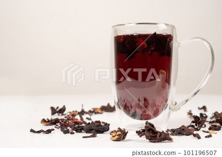 Red hibiscus tea from the petals of the Sudanese rose in a glass cup with a double bottom Red hibiscus tea from the petals of the Sudanese rose in a glass cup with a double bottom 101196507