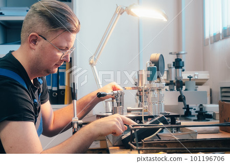 Professional calibration of pressure gauges and sensors. Working man is engaged in verification of Professional calibration of pressure gauges and sensors. Working man is engaged in verification of 101196706