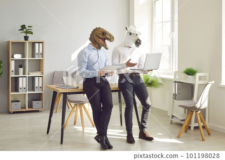 Team of two business people in funny animal masks using laptop computer in office 101198028