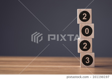 Number 2023 write on wooden blocks and arranged on office wooden table. Use for the idea of start up for new Learning, Education or working in 2023 Concept. 101198197