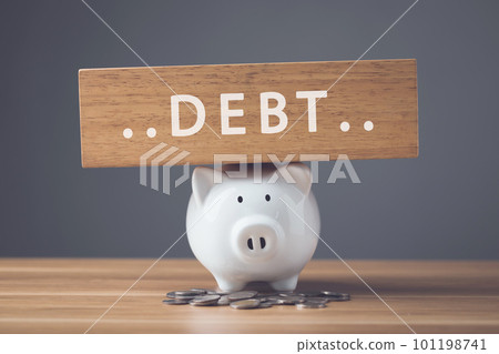Financial problem, Bankrupt or fail in business concept. White of new piggy bank, coin stack and word DEBT write on wooden board on wooden desk with dark wall. Financial problem, Bankrupt or fail in business concept. White of new piggy bank, coin stack and word DEBT write on wooden board on wooden desk with dark wall. 101198741