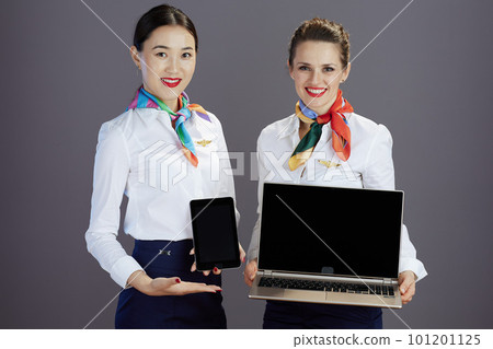 air hostess women showing tablet PC and and laptop blank screen 101201125