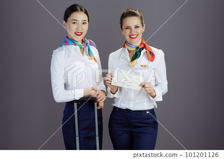 happy elegant air hostess women against grey background happy elegant air hostess women against grey background 101201126
