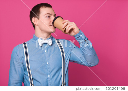 Indian/asian young man holding paper coffee cup with a black plastic cap isolated on a white background in the studio, advertising coffee 101201406